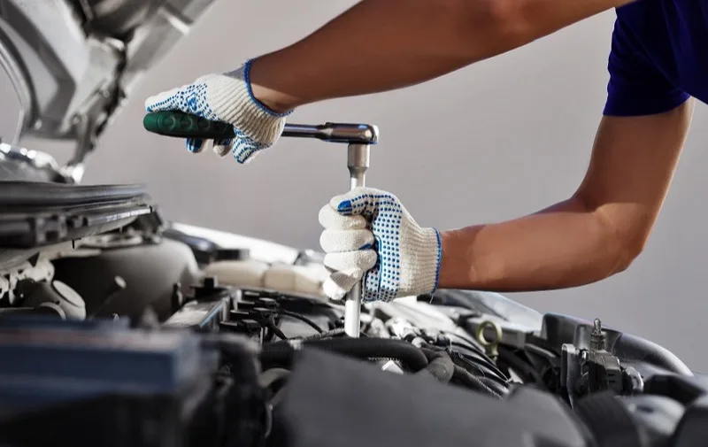 Mechanic performing an oil change and engine service at Kennedy's Auto Repair